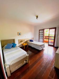 a bedroom with two beds and a sliding glass door at Refúgio com piscina e churrasqueira in Sao Paulo