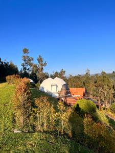 une tente blanche sur une colline dans un champ dans l'établissement Golden Glamping, à Guatavita