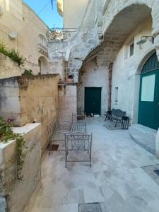 un patio en un edificio de piedra con bancos en Casa Masiello La casa tipica dei Sassi di Matera, en Matera