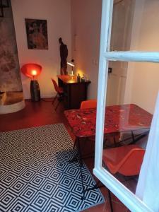 uma sala de estar com uma mesa vermelha e uma secretária em Ô Anges em Arles