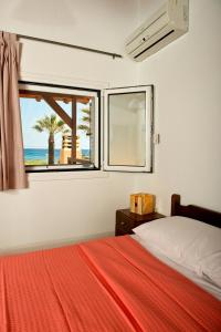 a bedroom with a bed and a window with the beach at Villa Nefeli in Kiotari