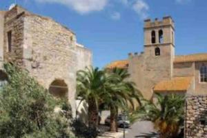 un bâtiment avec des palmiers et une tour d'horloge dans l'établissement Grand appartement 3 chambres avec garage, à Lapalme