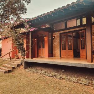 una casa con porte in legno e portico di Retiro com lareira em frente à reserva ambiental a Carapicuíba