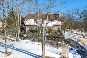 una casa en la nieve con un árbol en Wolf Hollow Harmony, en Lake Harmony