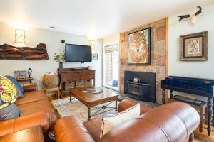 a living room with leather furniture and a fireplace at Camp Cottonwood in Teton Village