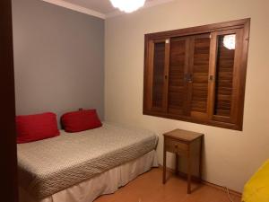 um pequeno quarto com uma cama e uma janela em Espaço gourmet e home-office na Granja em São Paulo