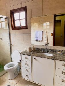 uma casa de banho com um WC, um lavatório e um chuveiro em Espaço gourmet e home-office na Granja em São Paulo