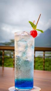 uma bebida azul com uma cereja na mesa em Villas Paradise em El Castillo de La Fortuna