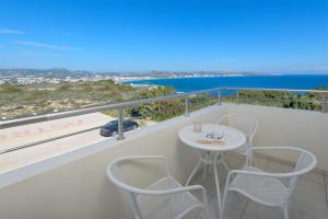 balcón con mesa, sillas y vistas al océano en Astronomy Studios, en Faliraki