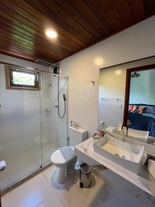 a bathroom with a shower and a sink and a toilet at Pousada Pedras Quentes in Lençóis
