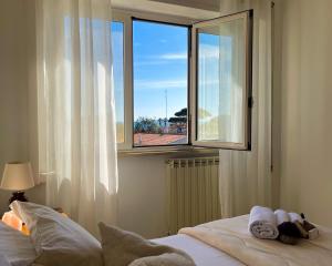 ein Schlafzimmer mit einem Bett und einem großen Fenster in der Unterkunft Kesya Seaview Apartment - Attico - 50mt dal mare in Anzio