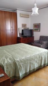 ein Schlafzimmer mit einem großen Bett und einem Sofa in der Unterkunft Affittacamere Villa Sofia con uso cucina e ampio giardino in Calcinelli