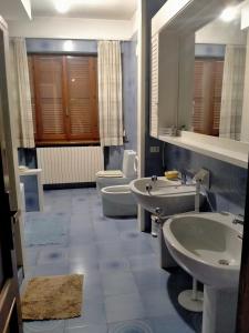ein Badezimmer mit 2 Waschbecken und 2 WCs in der Unterkunft Affittacamere Villa Sofia con uso cucina e ampio giardino in Calcinelli