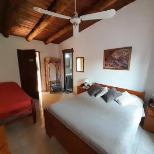 a bedroom with a white bed and a ceiling fan at La Montaña in Cafayate