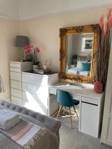 a bedroom with a desk with a mirror and a bed at Luxury Accomodation close to city centre in Plymouth