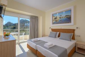 a bedroom with a bed and a large window at Astronomy Studios in Faliraki