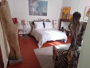 Un dormitorio con una cama y una estatua. en Ô Anges en Arles