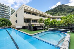 a swimming pool in front of a building at Executive Oceanside Apartment in Mount Maunganui