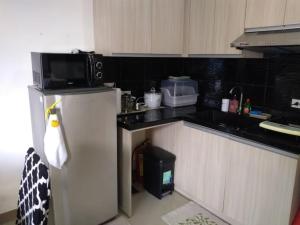 a kitchen with a refrigerator and a microwave at Mabolo Garden Flats in Cebu City