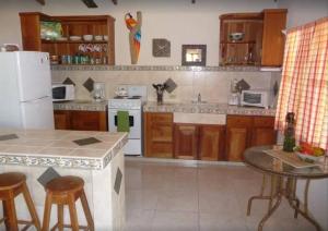 a kitchen with a white refrigerator and a table at Casa Sammie: True Costa Rica in Tarcoles