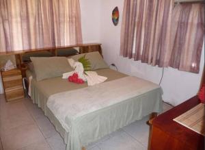 un dormitorio con una cama con un animal de peluche en Casa Sammie: True Costa Rica, en Tarcoles
