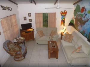 a living room with two couches and a tv at Casa Sammie: True Costa Rica in Tárcoles