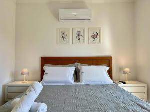 グラマドにあるApto 2dorm 500m Rua Coberta by Achei Gramadoのベッド、ナイトスタンド2台、ランプ2個を備えた寝室