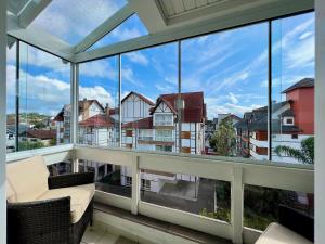 グラマドにあるApto 2dorm 500m Rua Coberta by Achei Gramadoの大きな窓付きのアパートメントのバルコニーから景色を望めます。