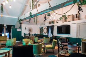 a room with chairs and tables and a tv at Chateau des Ayes - Chambres & suites in Saint-Étienne-de-Saint-Geoirs
