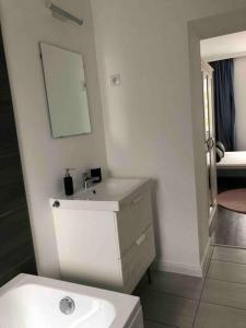 ein Badezimmer mit einem weißen Waschbecken und einem Spiegel in der Unterkunft Quattro Casa in Sopron