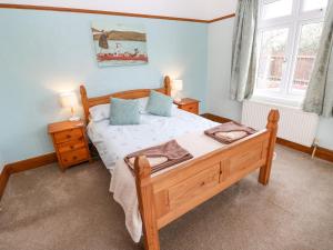 a bedroom with a bed and two lamps and a window at Trelydarth in St. Agnes 