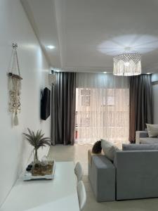 a living room with a couch and a chandelier at Studio SvEt in ParC Mohammedia in Mohammedia