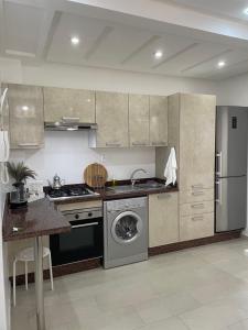 a kitchen with a washing machine and a stove at Studio SvEt in ParC Mohammedia in Mohammedia
