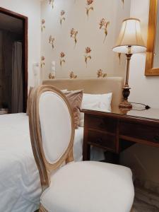 a bedroom with a desk and a chair next to a bed at Five Seasons Pension in Nafplio