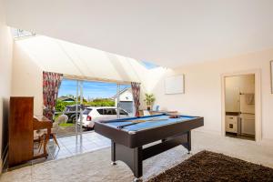 uma sala de estar com uma mesa de bilhar em 4Bed Spacious Villa in Chatswood em Auckland