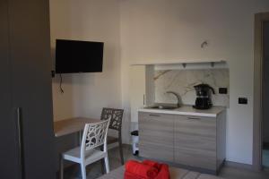 uma pequena cozinha com um lavatório, uma mesa e cadeiras em B&B Alba Chiara em Paola