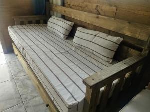 1 cama de madera con 2 almohadas en Cabaña de Montaña en Luján de Cuyo