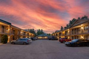 a sunset over a parking lot at a motel at SureStay Plus Hotel by Best Western Salmon Arm in Salmon Arm