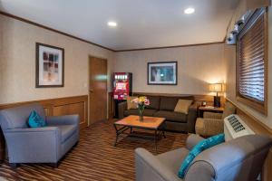 a living room with couches and a table at SureStay Plus Hotel by Best Western Salmon Arm in Salmon Arm