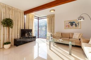 a living room with a couch and a tv at Zen Villa Anfi Tauro Golf Meer Pool in Mogán