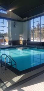 a large swimming pool with blue water in a building at Best Western Plus Prince George in Prince George