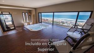 uma ampla sala de estar com uma banheira de hidromassagem e o oceano em Hotel AATRAC em Mar del Plata