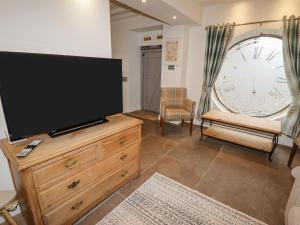 a living room with a flat screen tv on a dresser at Clock Cottage in Oldham