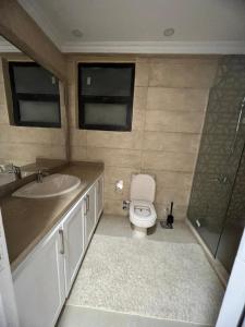 a bathroom with a toilet and a sink and a shower at كمبوند بيفرلي هيلز سوديك الشيخ زايد in Sheikh Zayed