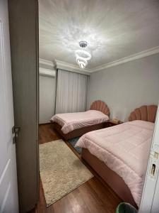 1 Schlafzimmer mit 2 Betten und einer Decke in der Unterkunft كمبوند بيفرلي هيلز سوديك الشيخ زايد in Sheikh Zayed