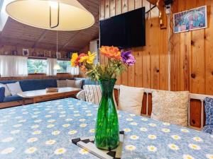 un jarrón verde con flores sentado en una mesa en 6 person holiday home in Gedser, en Gedser