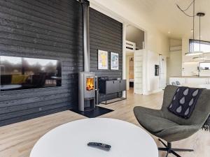 a living room with a fireplace and a table and chairs at Holiday home Væggerløse CCXVII in Bøtø By