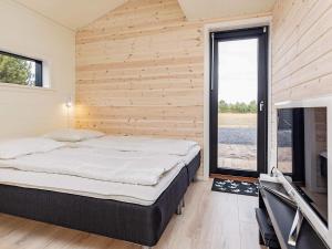 een slaapkamer met een bed en een groot raam bij Holiday home Væggerløse CCXVII in Bøtø By