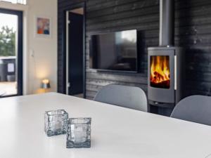 two glasses sitting on a table in front of a fireplace at Holiday home Væggerløse CCXVII in Bøtø By