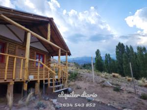 a log cabin with a view of the mountains at La margarita in Potrerillos